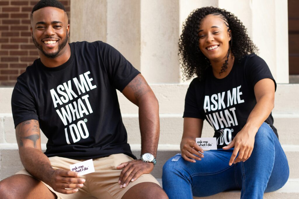 A black man and a black woman wearing black shirts sitting on the stairs